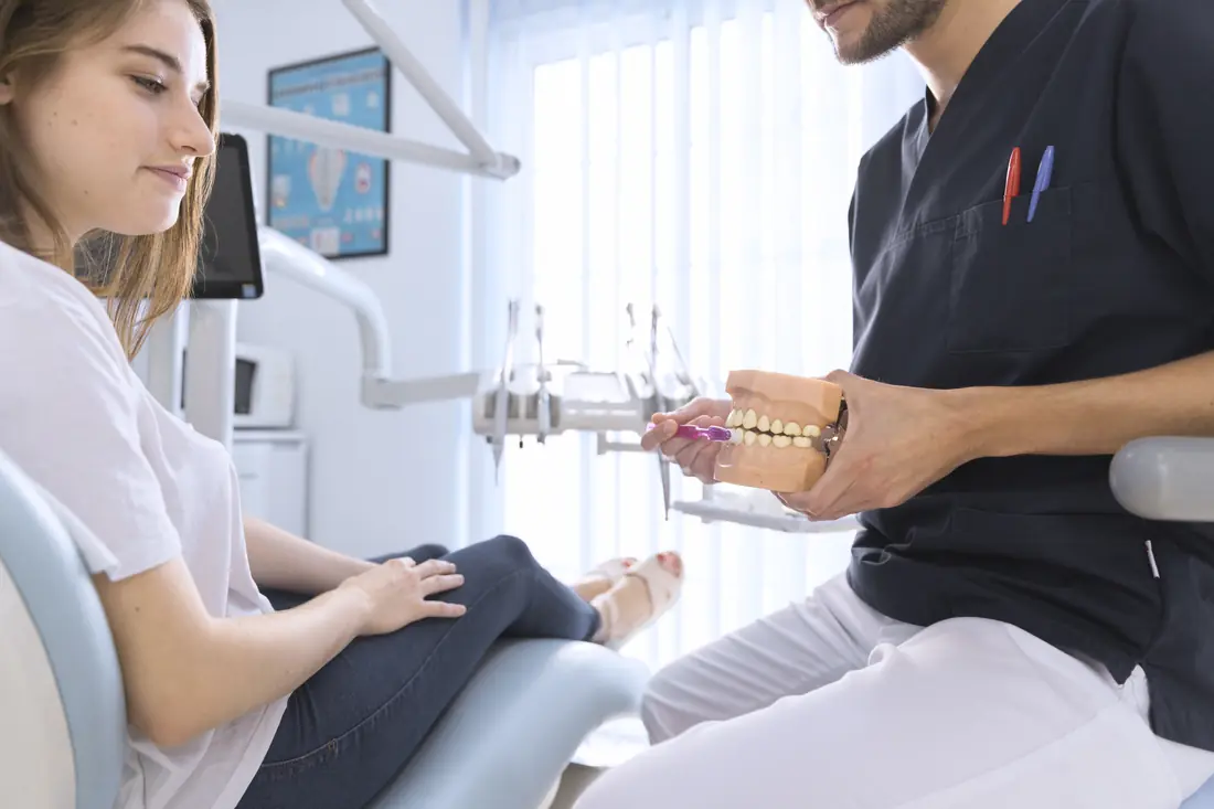 Medic stomatolog arătând tehnica de periaj pe un model dentar