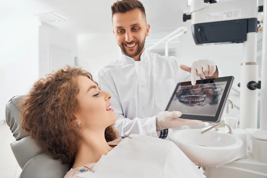 Medic stomatolog arătând radiografia pe tabletă unei paciente